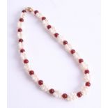 A necklace of freshwater pearls and garnets, length 45cm.