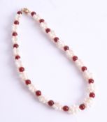 A necklace of freshwater pearls and garnets, length 45cm.