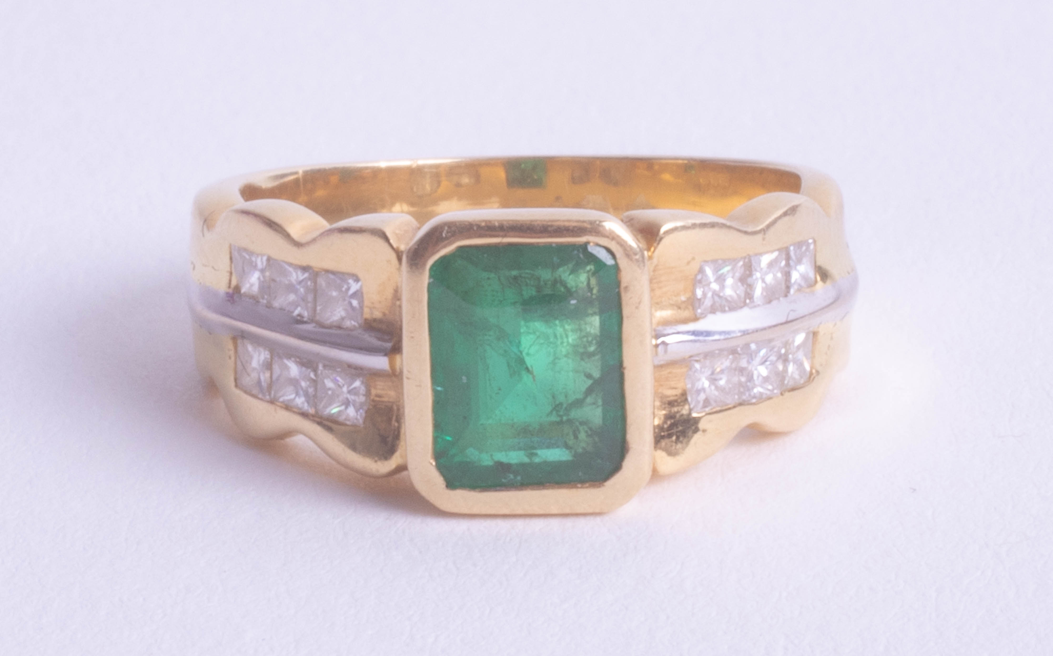An 18ct yellow gold emerald and diamond ring, size O.