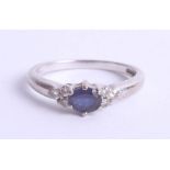 An 18ct white gold ring set with a central sapphire and six small diamonds, size K.