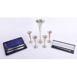 A weighted silver single flute, height 25cm, together with a group of four smaller silver flutes and
