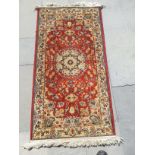 A small patterned floor rug, 0.70m x 1.35m.
