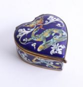 An early 20th century French enamel heart shaped box, decorated with a long red tongued lizard, a