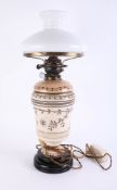 A Victorian oil lamp with opaline shade, damaged, height 60cm.