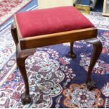 A mahogany framed dressing table stool on claw ball feet.