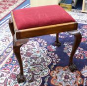 A mahogany framed dressing table stool on claw ball feet.