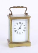 A carriage clock, brass case, Roman numerals, with key, height 14cm, handle up.