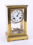 A brass four glass clock with pendulum and key, overal height 22cm.