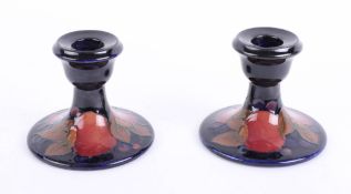 Two Moorcroft pomegranate candlesticks.