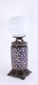 Royal Doulton, an art pottery oil lamp, damaged, with opaline shade, height including shade 52cm.