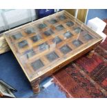 A carved wood Indian panelled coffee table with glass top, 78cm x 100cm x 40cm.