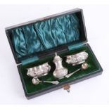 A Victorian silver salt and pepper set, with two spoons, cased. (5)