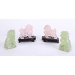 A pair of pink marble?oriental Foo Dogs and a pair of green similar dogs, height 9cm.