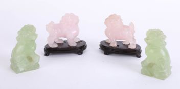 A pair of pink marble?oriental Foo Dogs and a pair of green similar dogs, height 9cm.