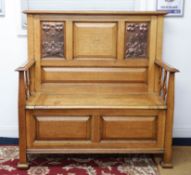 A golden oak hall seat with art nouveau embossed copper panels, the seat with hinged lid enclosing a