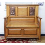 A golden oak hall seat with art nouveau embossed copper panels, the seat with hinged lid enclosing a