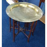 A Chinese brass top table with hardwood folding base.