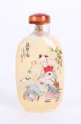 An oriental glass snuff bottle, decorated with children and script, length 85mm.