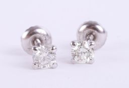 A pair of 14k white gold round cut diamond stud earrings, colour D-E, clarity VS1, total carat
