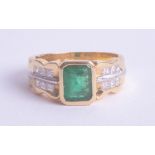 An 18ct yellow gold emerald and diamond ring, size O.