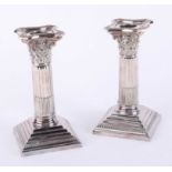 A pair of Walker and Hall Corinthian column candlesticks, each with removal sconces with step bases,