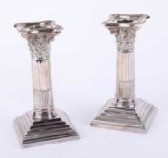 A pair of Walker and Hall Corinthian column candlesticks, each with removal sconces with step bases,