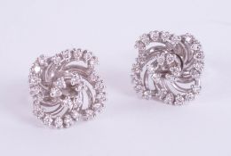 A pair of 18ct and diamond set swirl earrings.