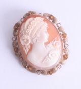 A large 9ct gold oval cameo brooch, depicting a period lady with floral hair decoration, approx.