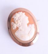 A cameo brooch depicting a period lady with floral hair decoration, approx. 7.55g.