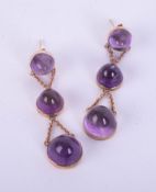 A pair of amethyst and yellow metal cabochon three stone earrings.