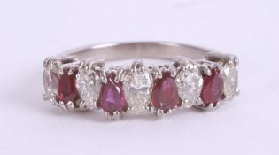 An 18ct white gold ruby and diamond ring, the nine stones of pear shape, size M.