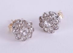 A pair of fancy diamond set cluster earrings.