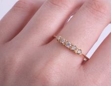 A five stone diamond ring set in unmarked yellow gold.