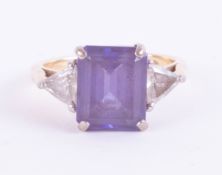 An 18ct emerald cut tanzanite and trillion cut diamond ring, tanzanite total weight 5.78ct, total