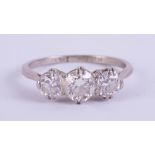 An early 20th century platinum and three stone diamond ring, size N.