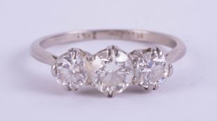 An early 20th century platinum and three stone diamond ring, size N.