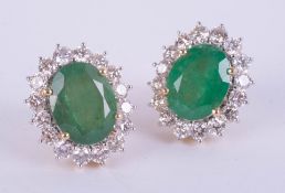 Large pair of 18ct yellow gold emerald and diamond cluster stud earrings, boxed. Emeralds 5.79ct,