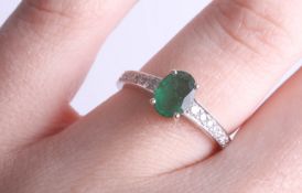 An 18ct white gold, emerald and diamond set ring, size K.