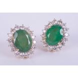 A large pair of 18ct yellow gold emerald and diamond cluster stud earrings, boxed, emerald weight