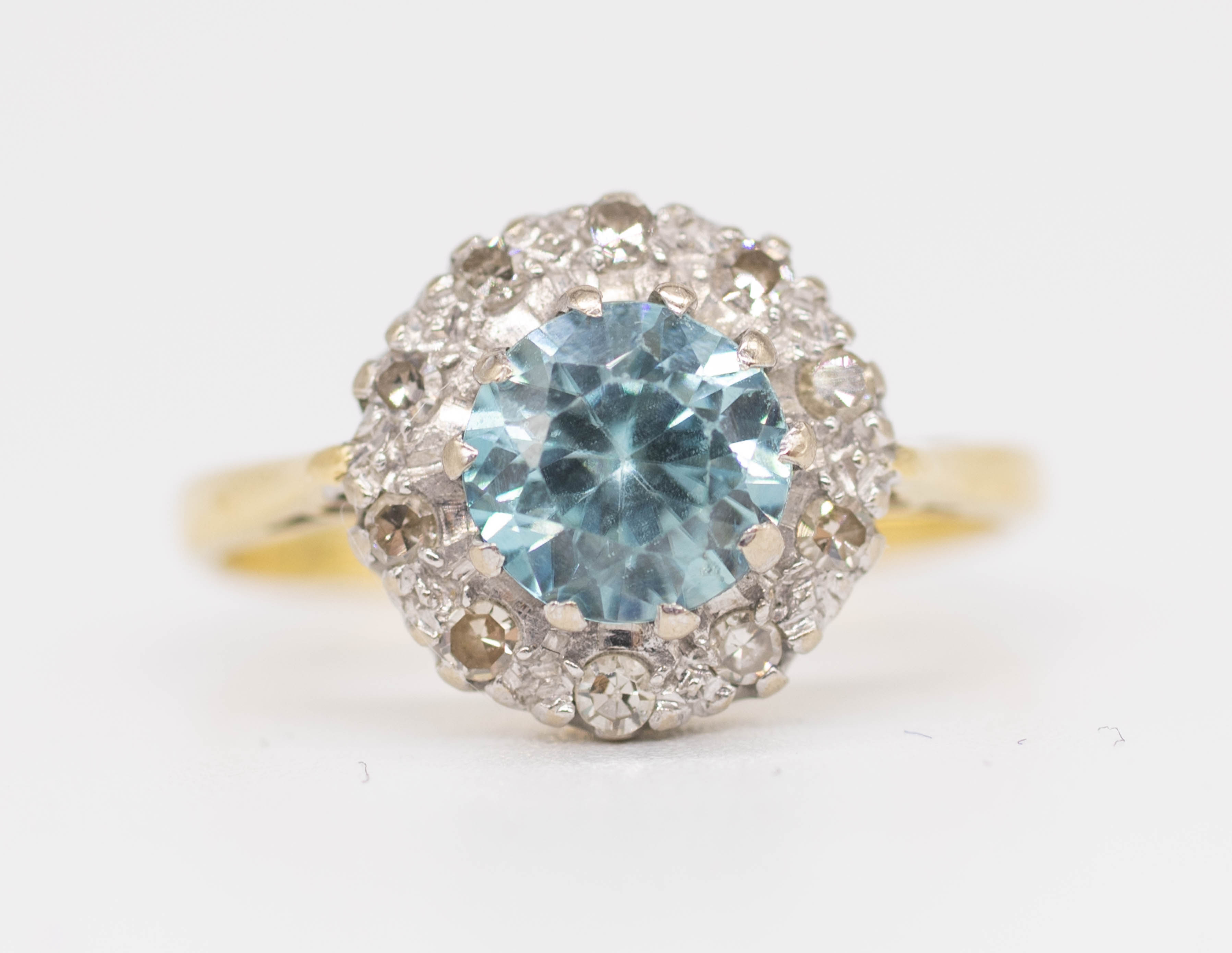 An 18ct blue zircon and diamond set cluster ring, size N.