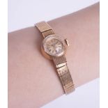 Omega, a ladies 9ct gold wristwatch with gold bracelet.