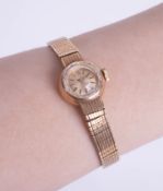 Omega, a ladies 9ct gold wristwatch with gold bracelet.