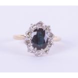 An 18ct white and yellow gold oval sapphire and diamond cluster ring, size O.