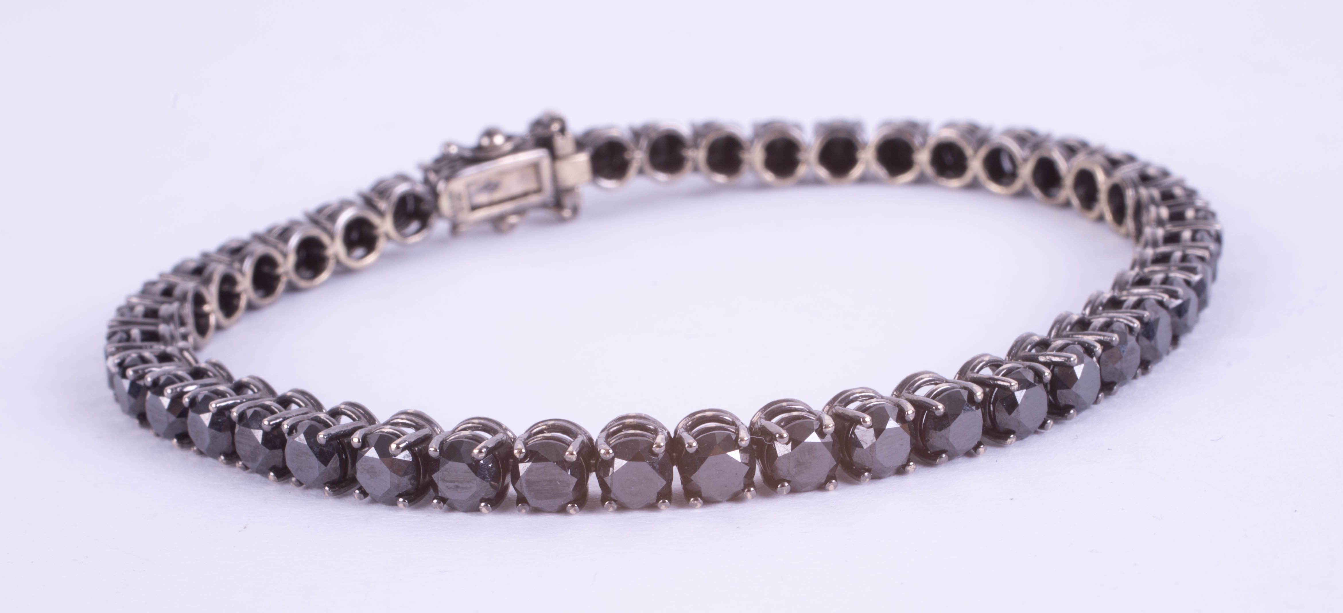 An 18ct white gold black diamond line bracelet, boxed, diamond weight approx 14.38ct.