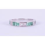 An 18ct white gold emerald and diamond half eternity ring, size M.