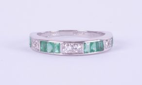 An 18ct white gold emerald and diamond half eternity ring, size M.