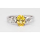 An 18ct yellow sapphire and diamond set three stone ring, size L.