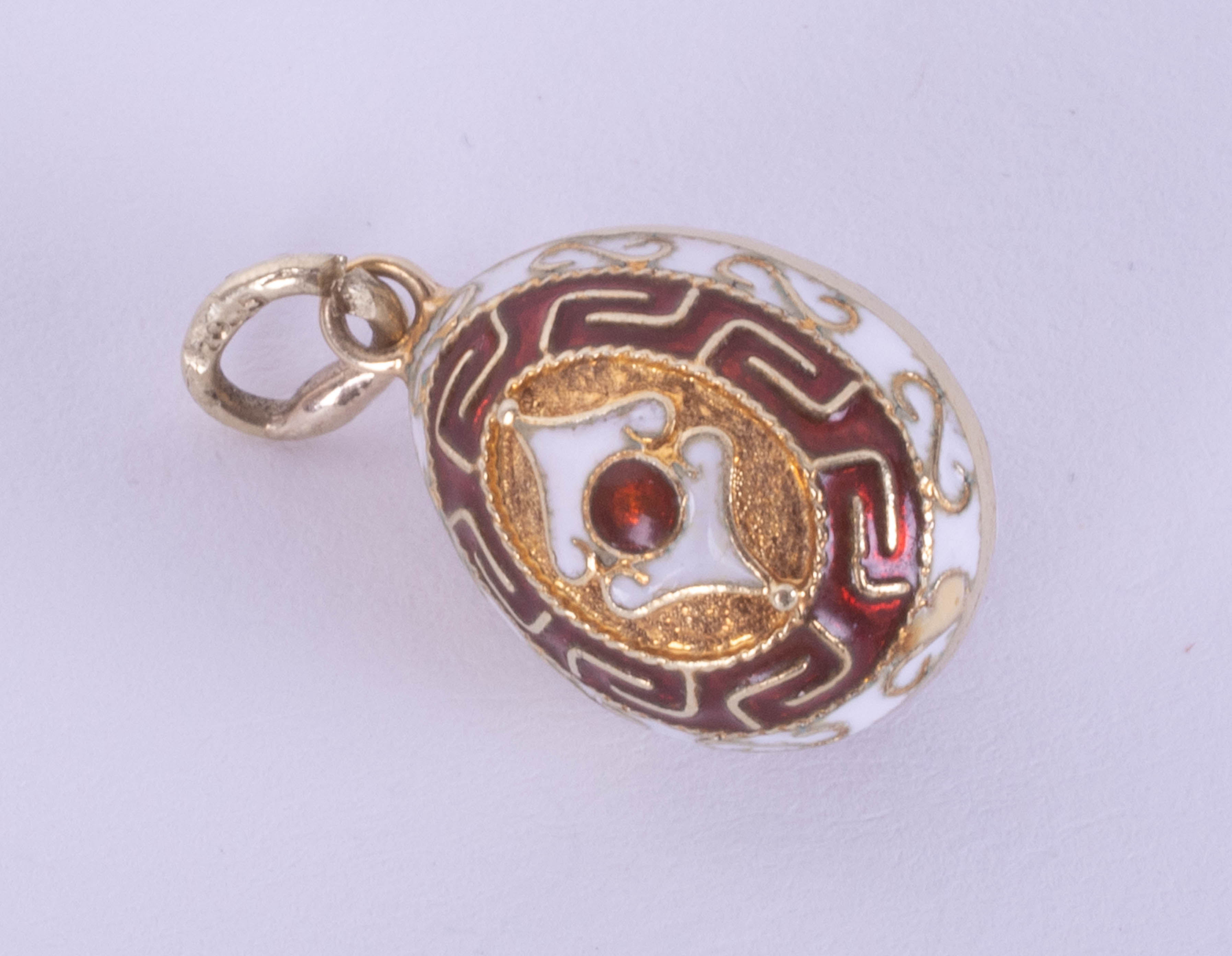 An enamel and silver egg pendant, diameter 13mm.