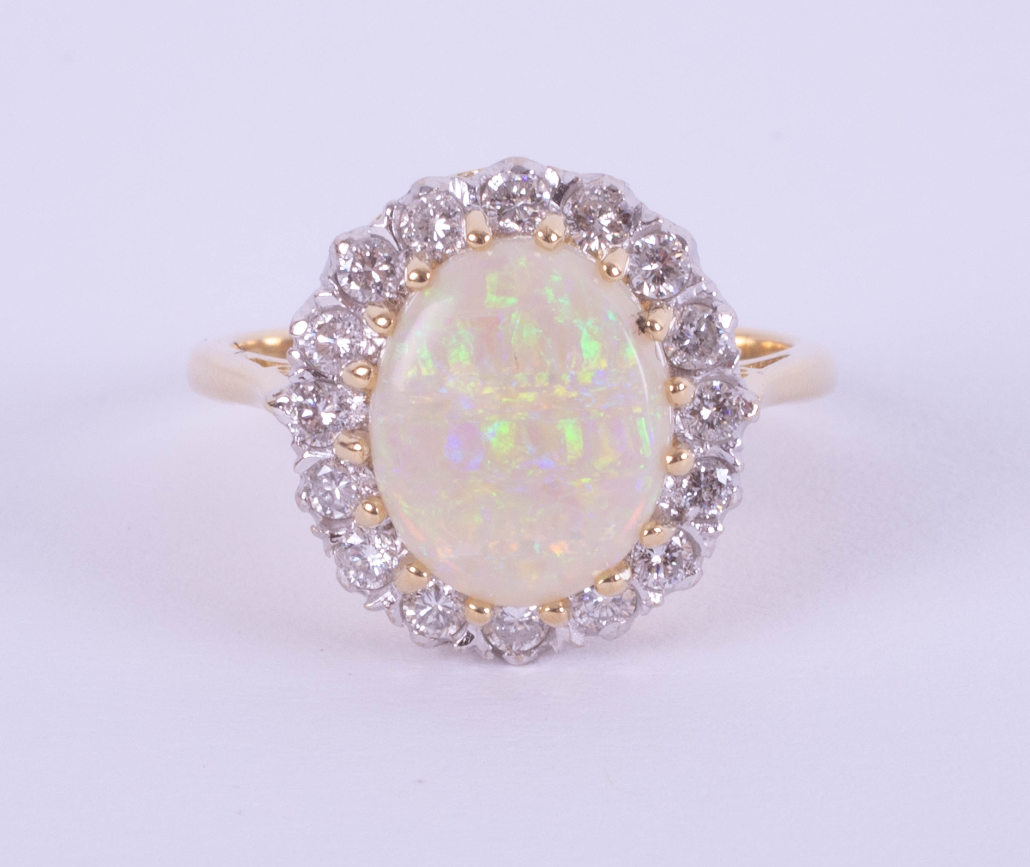 An 18ct white and yellow gold oval opal and diamond cluster ring, size P.