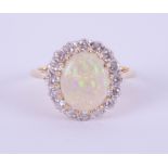 An 18ct white and yellow gold oval opal and diamond cluster ring, size P.
